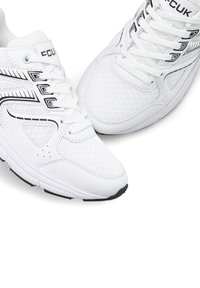 Weiße Sportschuhe mit Oberschuh aus Mesh, schwarzen Akzenten und sechs Ösen für die Schnürsenkel. Verfügt über eine strukturierte Sohle für Halt und Komfort.