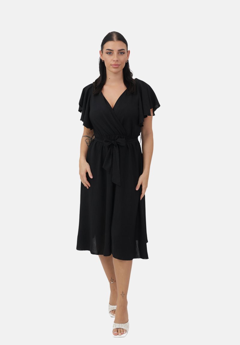 Vestido negro con mangas flotantes, cinturilla con lazo y falda a la altura de la rodilla. Tejido suave con textura lisa y diseño minimalista.