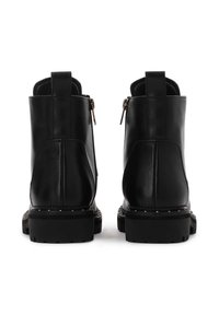 Cizme negre din piele până la glezna, cu închidere cu zipper, guler căptușit, talpă din cauciuc rezistentă și duiuri decorative pe marginea tălpii.