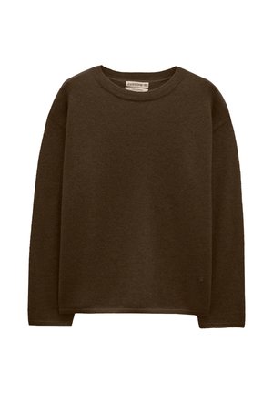 Brązowy sweter wykonany z miękkiej, teksturowanej tkaniny. Posiada okrągły dekolt i opadłe ramiona, z minimalnym widocznym logo na hemie.