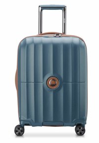 Valigia rigida blu con scanalature diagonali testurizzate, dettagli marroni, maniglia telescopica e quattro ruote nere per la mobilità.
