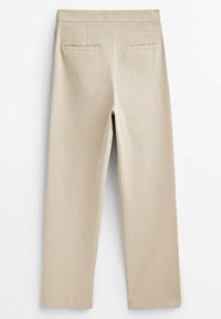 Pantalons beiges avec une texture lisse, présentant une coupe droite, deux poches arrière et une taille sans fermetures visibles.