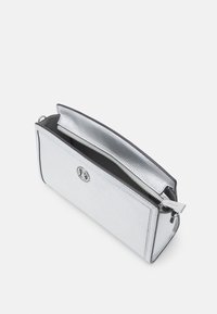 Borsa in pelle argentata con superficie testurizzata, chiusura con zip e dettaglio del logo. L'apertura superiore rivela un rivestimento interno nero.