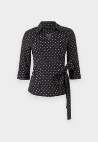 Camicia avvolgente nera con pois bianchi, dotata di colletto, maniche a tre quarti e un dettaglio annodato in vita. Tessuto di cotone morbido.