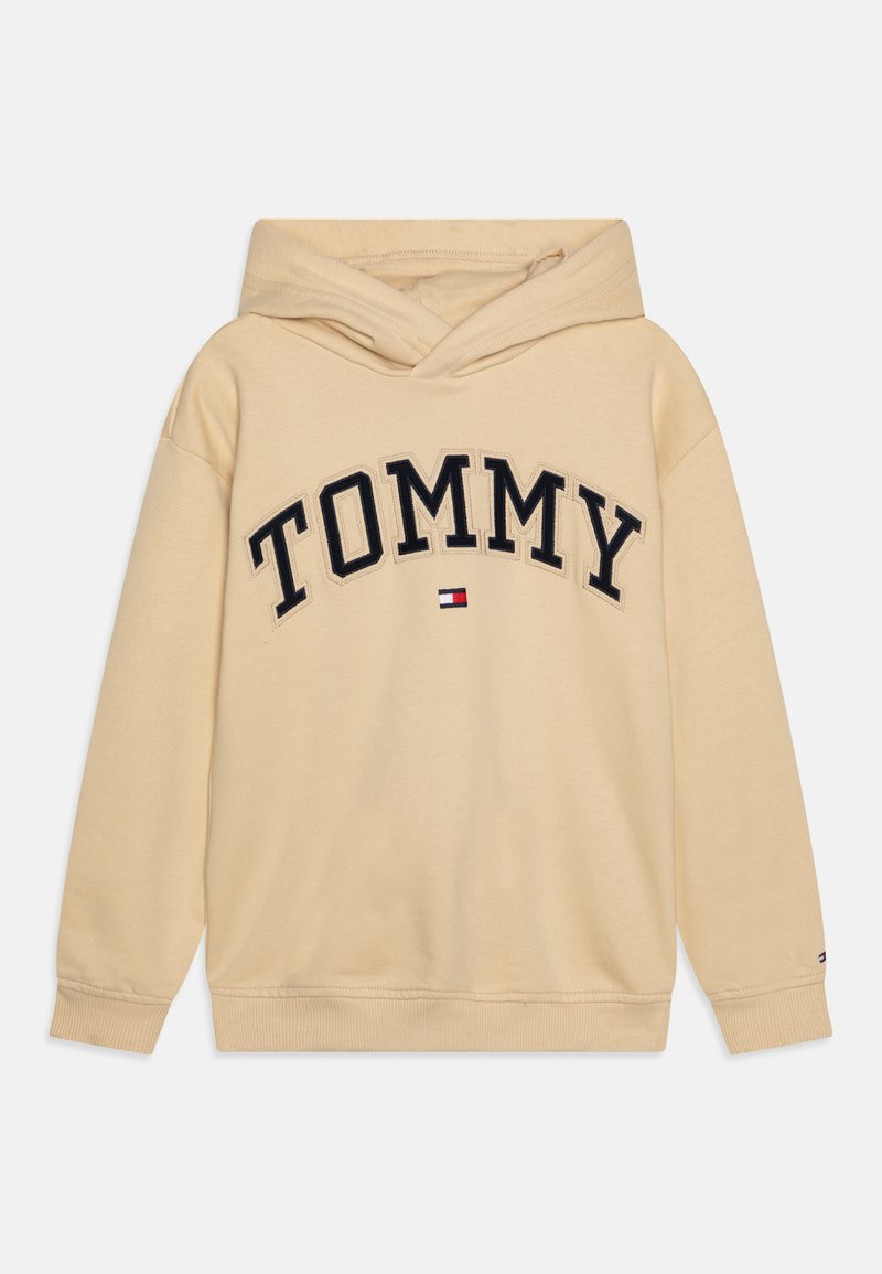 Felpa beige con tasca a marsupio frontale, caratterizzata da un logo "TOMMY" ricamato in blu navy e accenti di branding rosso, bianco e blu. Tessuto morbido.