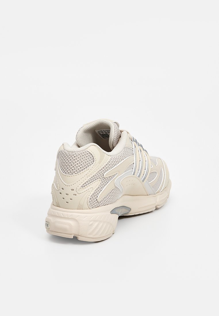 Beige Mesh-Sneaker mit strukturierten Überzügen, gepolsterter Ferse, kontrastierenden weißen Streifen und einer dicken Gummisohle.