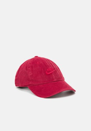 Casquette de baseball en velours côtelé rouge avec visière courbée et logo Nike Swoosh brodé à l'avant, présentée sur un fond blanc uni.