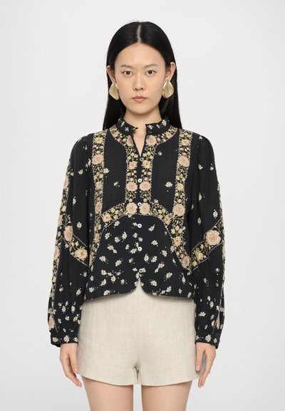Schwarze Bluse mit floraler Stickerei, Knopfleiste, Kragen und langen Ärmeln. Verfügt über einen strukturierten Stoff und ein leicht verkürztes Design.