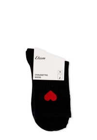 Calze nere a costine con un design a forma di cuore rosso, etichettate "Etam" e "Chaussettes Socks" su un imballaggio bianco.