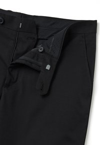 Zwarte broek met ritssluiting, knoopsluiting en zijzakken. Heeft een gladde textuur en een getailleerde pasvorm.