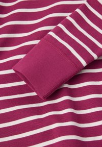 Fuksia ja valkoinen raidallinen puuvillakangas, jossa on sileä rakenne. Sisältää hihansuun, jossa on kiinteä fuksia-nauha.