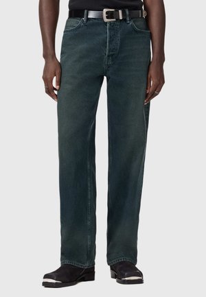 Dark green denim jeans with a relaxed fit, five-pocket design, and visible stitching. Paired with a black belt and black footwear.