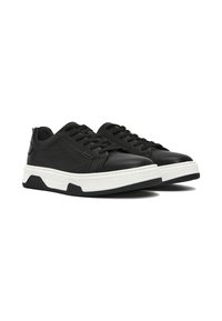 Sneaker neri in pelle con finitura testurizzata, suola intermedia bianca e suola esterna in gomma nera. Presentano un design classico con lacci e un collarino imbottito.