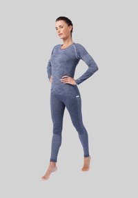 Langermige, aansluitende sporttop en legging in donkerblauw met geometrisch patroon en textuurlijnen. Gemaakt van rekbaar, vochtafstotend materiaal.