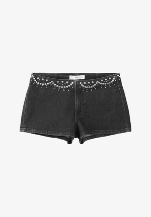 Short en jean noir avec des ornements cloués argentés formant des motifs courbes le long de la ceinture, fermeture éclair avant et passants visibles.