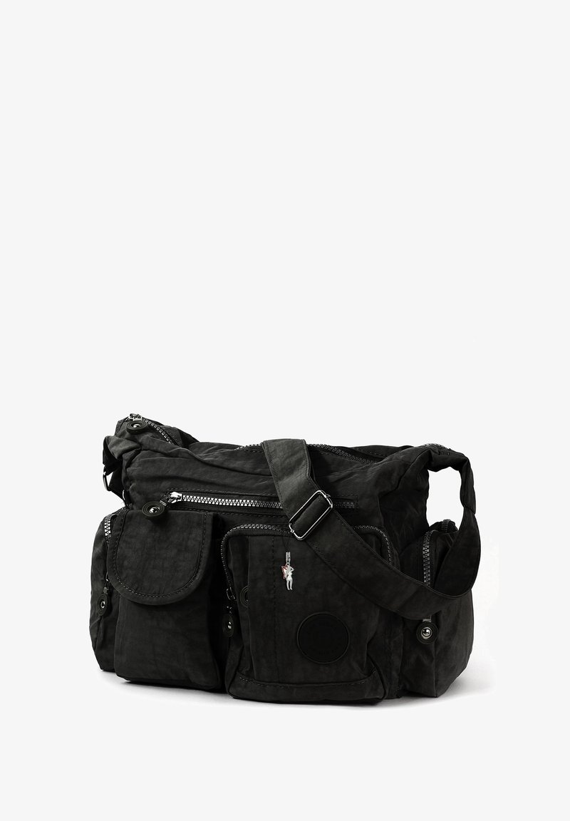 Zwarte stoffen schoudertas met meerdere ritsvakjes, een voorklep-tas, een verstelbare schouderband en een klein decoratief hangertje.