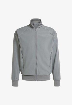 Grijze ritsjack met een hoge kraag, geribde manchetten, zijzakken en het Adidas-logo op de borst; gladde textuur, atletisch ontwerp.