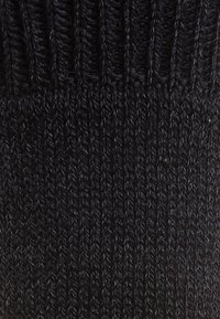 Tela de punto negra con textura acanalada, presenta un patrón vertical y puntadas finas, adecuada para prendas o accesorios.