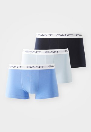 Tri para GANT bokseric v temno modri, svetlo modri in pastelno modri barvi. Vsaki imajo bel pas z ponavljajočim se besedilom "GANT". Mehka bombažna tkanina.