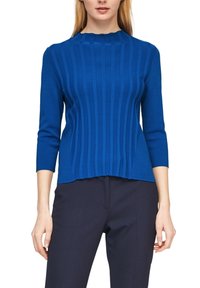 Blå ribbad stickad topp med hög krage och trekvartslång ärm, med en veckad nederkant och en slät yta.