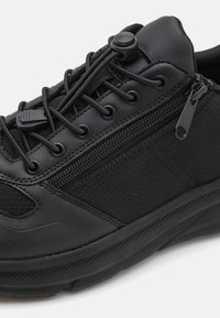 Czarny but sportowy wykonany z mieszanki gładkiej skóry i teksturowanej tkaniny, z elastycznymi sznurówkami oraz bocznym zamkiem błyskawicznym dla łatwego zakładania.