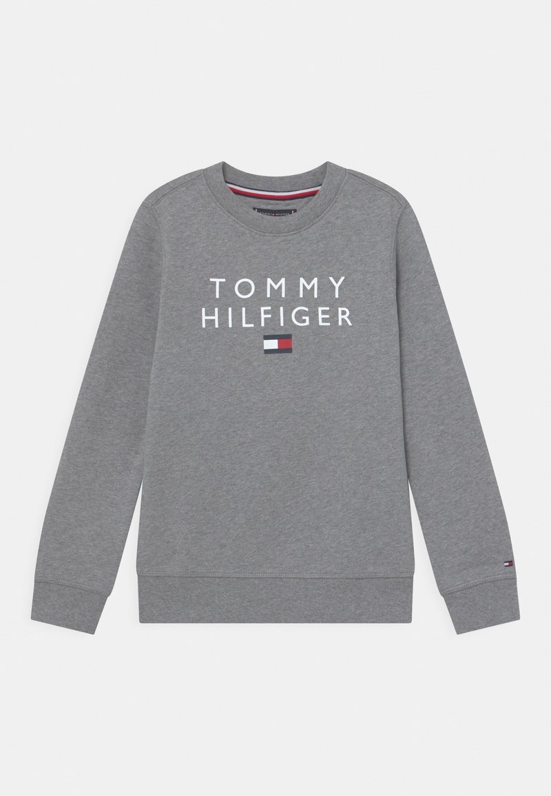 Sweat-shirt gris Tommy Hilfiger avec texte logo blanc et petit emblème en rouge, blanc et bleu à l'avant et sur le poignet.