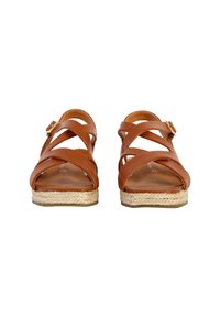 Sandales en cuir marron avec des bretelles croisées, des accessoires de fixation et une semelle tissée en jute. Design ouvert au niveau des orteils avec une semelle plate.