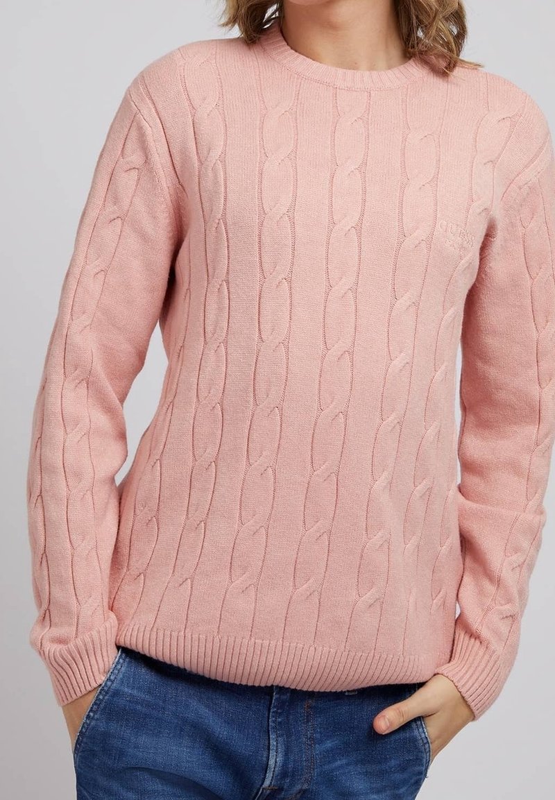 Hellrosa, aus Kabelstrick gefertiger Pullover mit Rundhalsausschnitt sowie gerippten Bündchen und Saum. Verfügt über dezentes Branding auf der Brust. Getragen mit blauen Jeans.