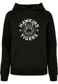 Čierna mikina s kapucňou s grafickým zobrazením tigra a bielym textom "HAWKINS TIGERS". Obsahuje prednú klokaniu kapsu a kapucňu so šnúrkou.
