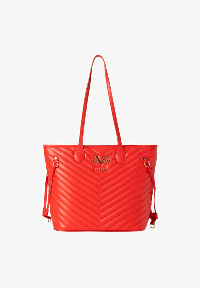 Red synthetic tote bag with chevron pattern, gold logo detail, dual handles, and adjustable side straps. Smooth texture, casual design.