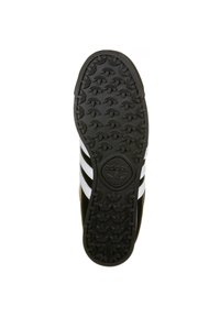 Černá podrážka tenisky s vyvýšeným vzorem trakce, se třemi bílými pruhy a reliéfním logem Adidas uprostřed.