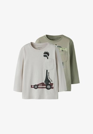 Divi garām piedurknēm t-krekli: viens gaiši pelēks ar dinozaura un automašīnas grafiku, otrs olīvu zaļš ar ceļa zīmes dizainu. Mīksts kokvilnas audums.
