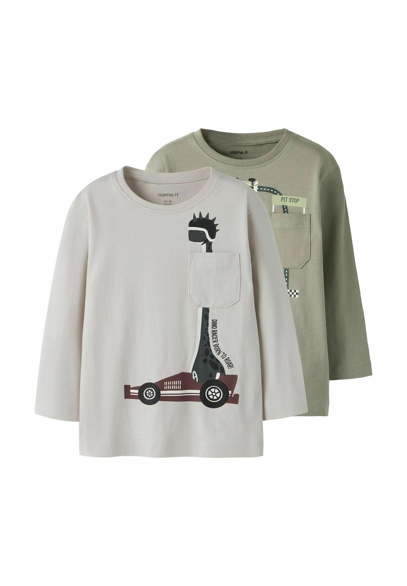 Två långärmade t-shirts: en ljusgrå med ett dinosaurie- och bilmotiv, en olivgrön med en vägskylt-design. Mjuk bomullstyg.