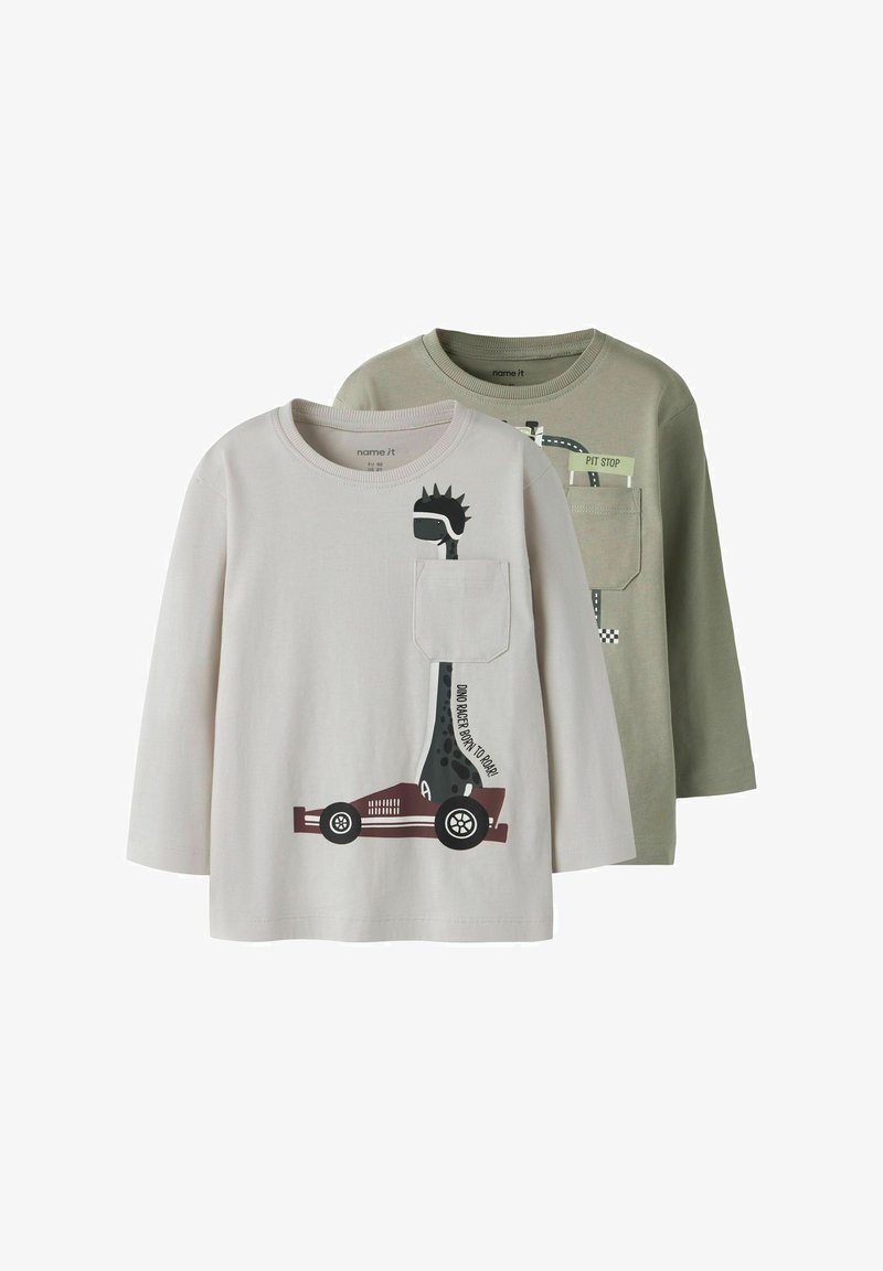 Två långärmade t-shirts: en ljusgrå med ett dinosaurie- och bilmotiv, en olivgrön med en vägskylt-design. Mjuk bomullstyg.