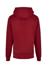 Röd bomullshoodie med långa ärmar, en kenguruficka och en dragsko på huvan. Slät textur, ribbade muddkanter och fåll. Enkelt design, inga mönster.