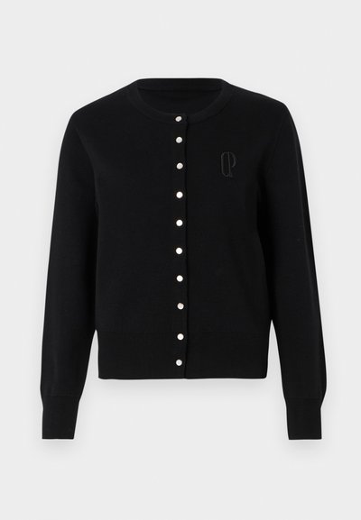 Melna adīta kardigāna izstrādājums. Tam ir apaļa kakla izgriezums, pogu aizdare ar baltām akcentiem un ribotām piedurknēm. Izšūts logo uz krūtīm.