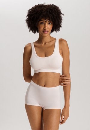 Set di reggiseno e culotte a boyshort di un delicato rosa chiaro, texture morbida, scollatura a girocollo, spalline larghe e vita elastica con finitura liscia.