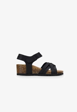 Schwarze Keilsandalen mit Kork-Zwischensohle, gekennzeichnet durch Kreuzriemen und verstellbaren Velcro-Riemen am Knöchel. Strukturierten Gummisohle für besseren Halt.