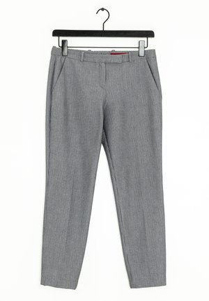 Szare spodnie w prążki wykonane z tkaniny tkanej, z bocznymi kieszeniami i pasem z pętlami na pasek, zawieszone na czarnym plastikowym wieszaku.