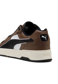 Braune Leder-Sneaker mit schwarzen und weißen Akzenten, strukturiertem Seitenpanel, gepolsterter Sohle und markiertem Logo an der Ferse.