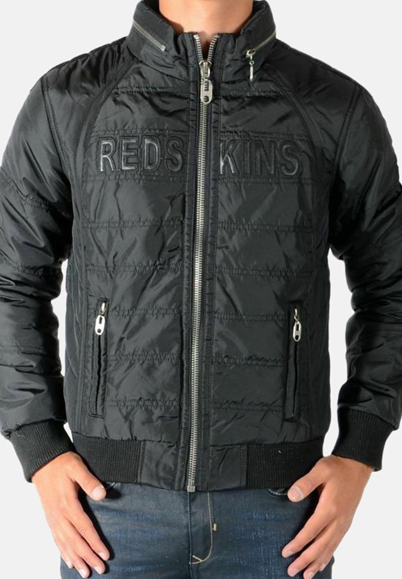 Sort quiltet jakke med høj krave, lynlås foran og ribstrikkede ærmegab. Har "REDSKINS" logo tværs over brystet samt sidelommer.
