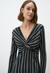 Langärmliges Kleid mit tiefem V-Ausschnitt, das über ein verdrehtes Vorderteil und vertikale Streifen in Grün, Beige und Dunkelblau verfügt.