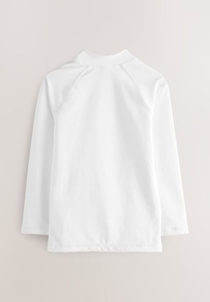 Biele tričko s dlhými rukávmi, vybavené vysokým golierom a raglánovými rukávmi. Hladká textúra s čistým zakončením a jednoduchým dizajnom.