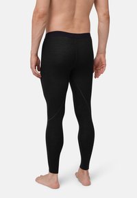 Black fitted leggings made from stretchy material, featuring a flat waistband and subtle stitching details along the seams.