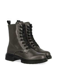 Černé šněrovací kotníkové boty vyrobené z metalicky šedé kůže. Mají texturovaný povrch, zesílenou špičku, silnou černou podrážku a poutko pro snadné obouvání.