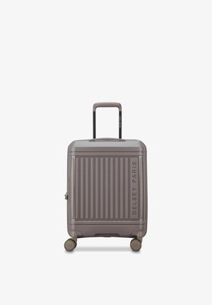 Compacte harde koffer met vier zwenkwielen, telescopische handgreep en verticale ribbels, aan de voorkant met het label "Delsey Paris".