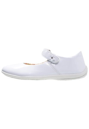 Weiße lackledere Mary Jane Schuhe mit runder Zehe, verstellbarem Riemen und strukturiertem Gummisohle. Blumenmuster-Innenfutter sichtbar.