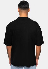 Sort kortærmet T-shirt med rund hals, der har en afslappet pasform og en glat bomuldsstruktur. Ensartet design uden mønstre eller accenter.