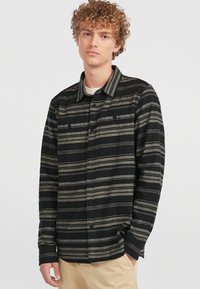 Zwart en grijs gestreept flanelhemd met een knoopsluiting, borstzakken en een iets relaxte pasvorm. Beschikt over een kraag.