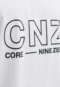 Hvid bomulds t-shirt med fed sort tekst, der står "CNZ CORE - NINEZ." Glat struktur med et afslappet design.